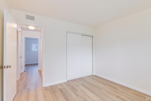 unfurnished bedroom featuring light wood-type flooring and a closet