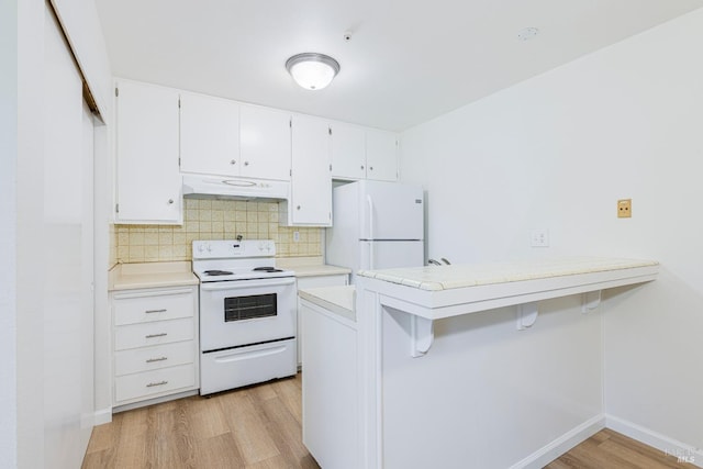 kitchen featuring kitchen peninsula, white appliances, white cabinetry, and a breakfast bar area