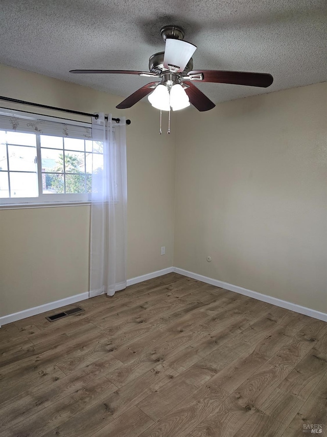 spare room featuring ceiling fan, a textured ceiling, and hardwood / wood-style flooring