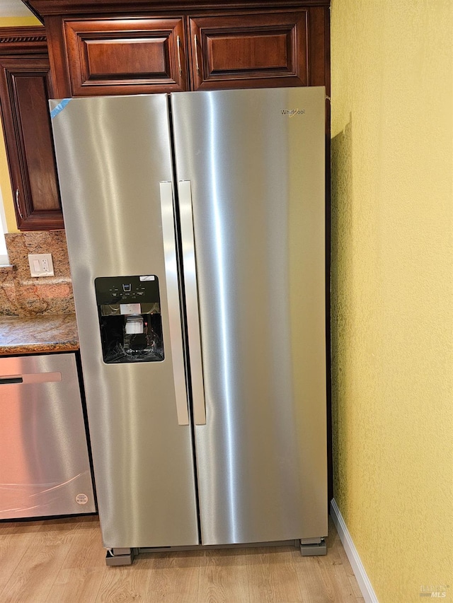 room details featuring dark brown cabinets, light wood-type flooring, and appliances with stainless steel finishes