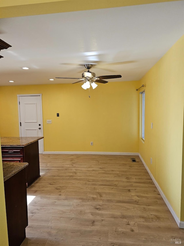 spare room with ceiling fan and light wood-type flooring