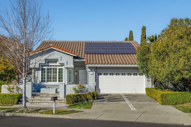 view of front of house featuring a garage and solar panels