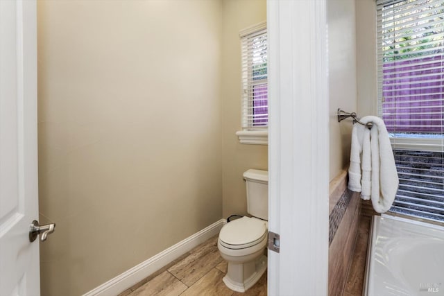 bathroom with toilet and hardwood / wood-style flooring