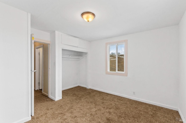 unfurnished bedroom with a closet and light carpet