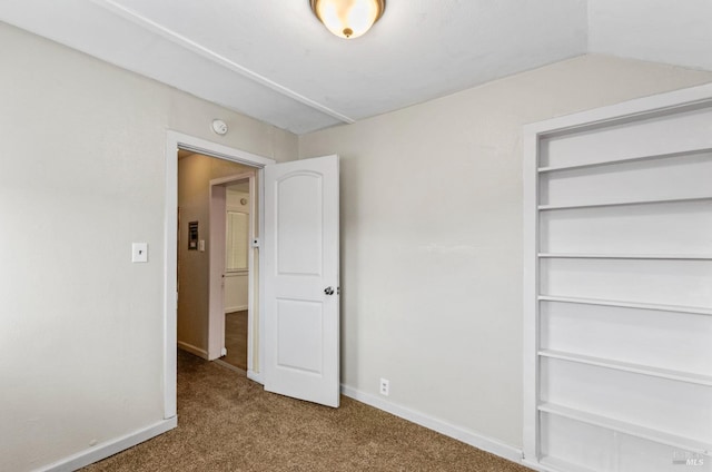 unfurnished bedroom featuring carpet flooring and vaulted ceiling