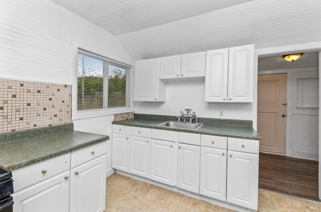 kitchen with lofted ceiling, sink, and white cabinets