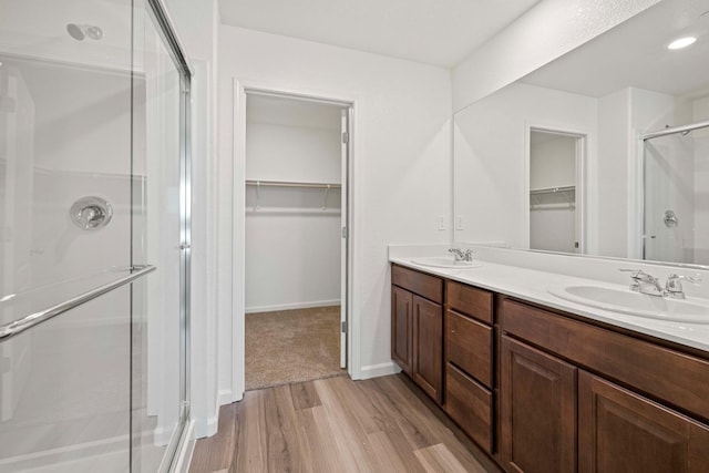 bathroom with vanity, hardwood / wood-style flooring, and a shower with door