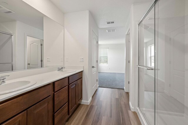 bathroom with hardwood / wood-style floors, vanity, and walk in shower