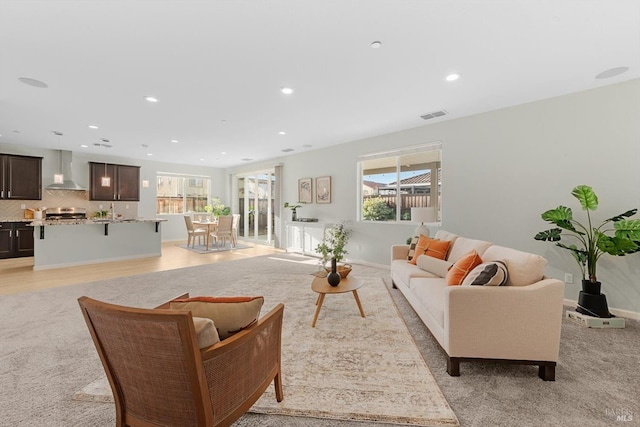 living room featuring recessed lighting, visible vents, light wood finished floors, and baseboards