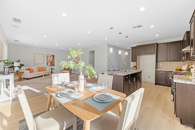 dining room featuring light wood-type flooring and sink