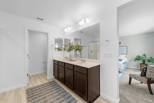 bathroom with a shower stall, connected bathroom, visible vents, and a sink