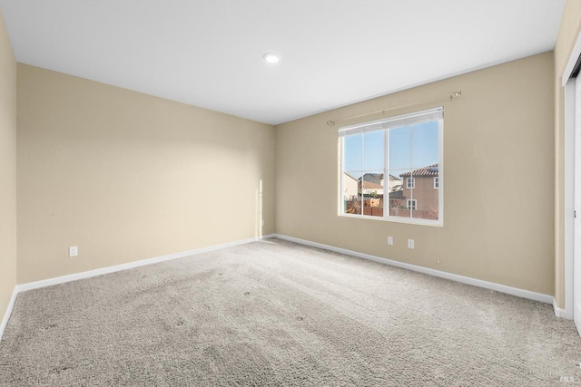 carpeted empty room with baseboards