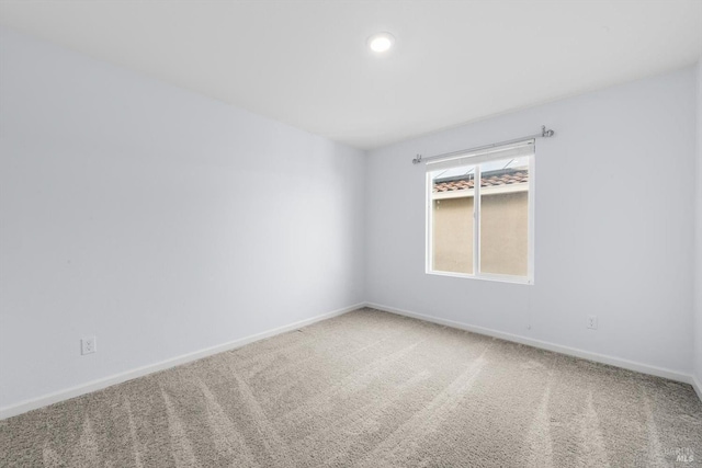 unfurnished room featuring baseboards and carpet