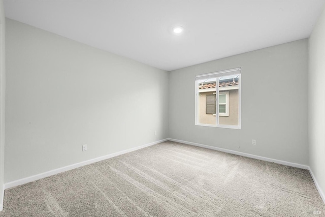 carpeted empty room featuring baseboards