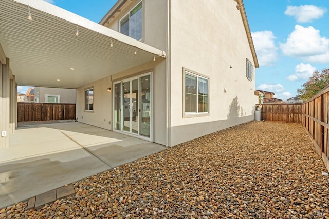 rear view of property with a patio, a fenced backyard, and stucco siding