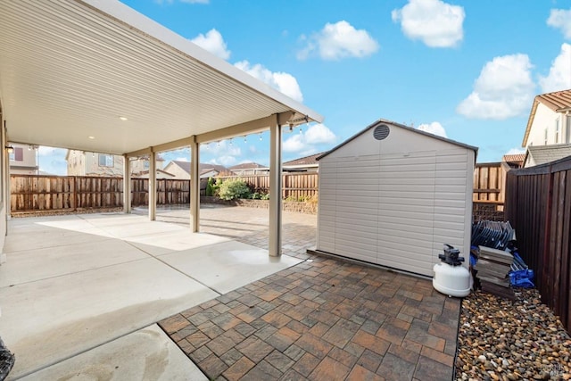 view of patio / terrace featuring an outdoor structure, a storage unit, and a fenced backyard