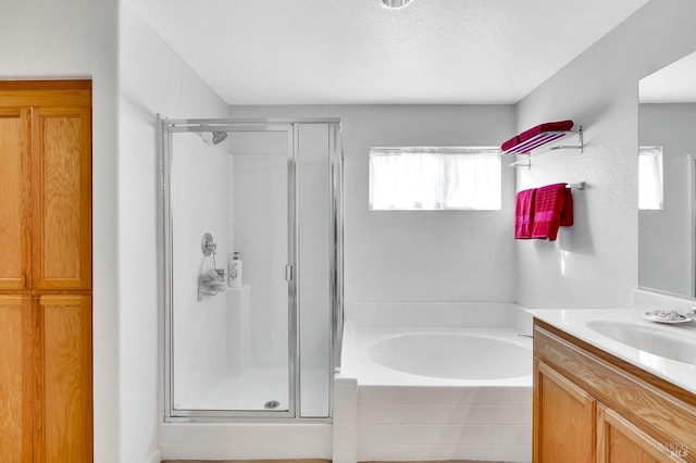 bathroom with separate shower and tub, a textured ceiling, and vanity