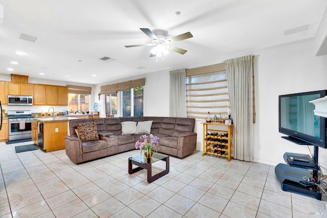 living room with sink, ceiling fan, and light tile patterned floors