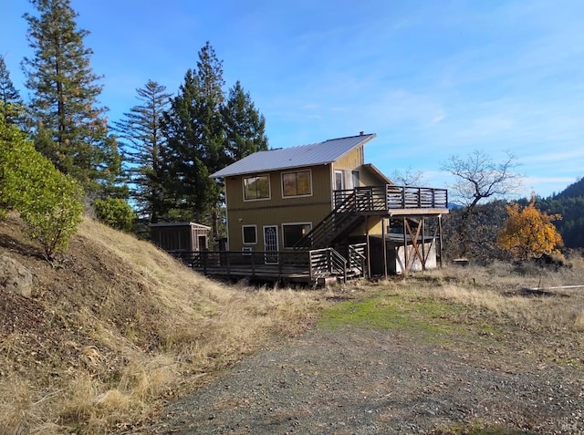 rear view of house featuring a wooden deck