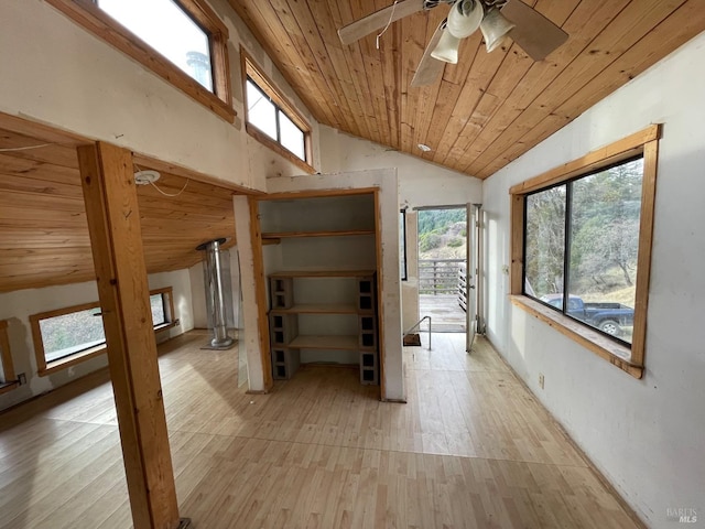 hallway featuring lofted ceiling, light wood-type flooring, wood ceiling, and a wealth of natural light