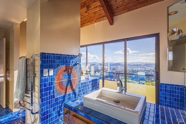 bathroom featuring sink, lofted ceiling with beams, tile patterned floors, a mountain view, and wood ceiling