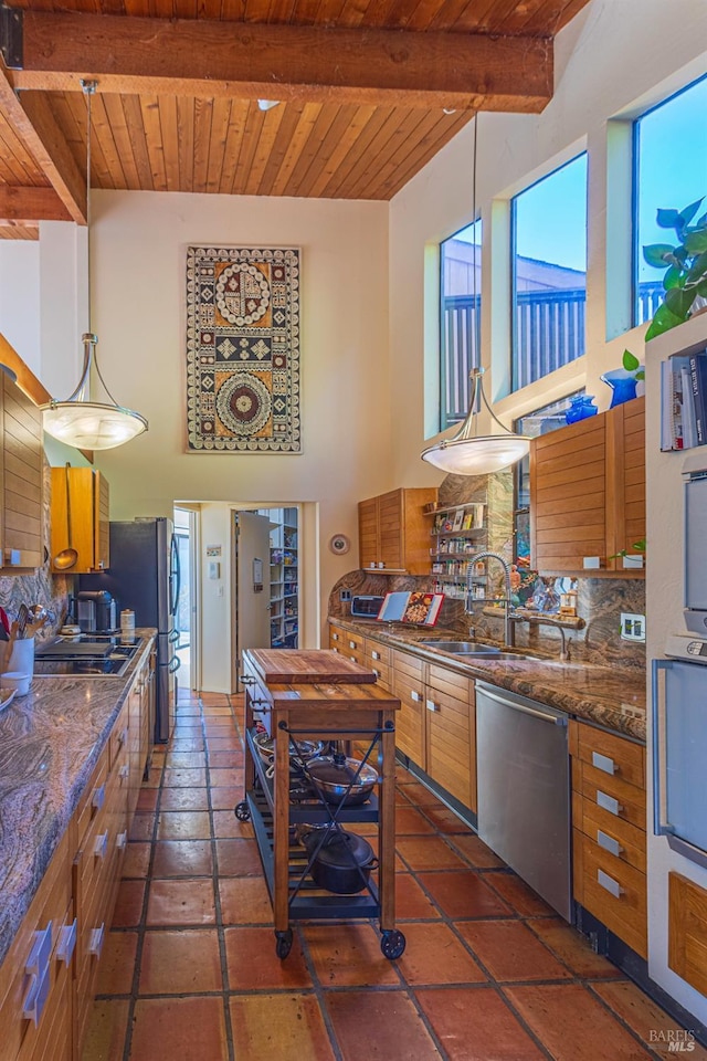 kitchen featuring stainless steel dishwasher, beam ceiling, decorative light fixtures, wooden ceiling, and a high ceiling