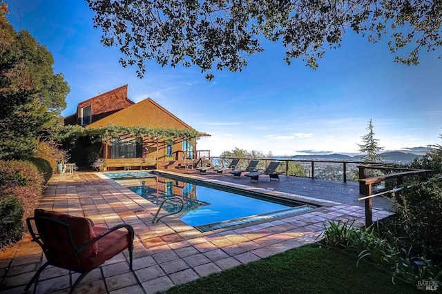 view of swimming pool featuring a patio area and a mountain view