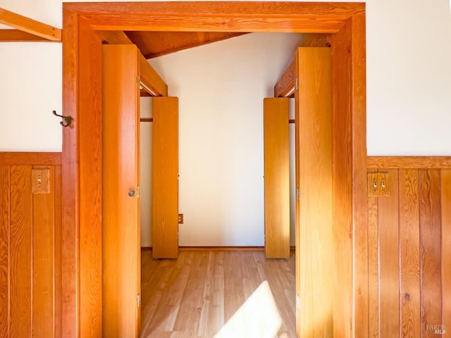 hall with light hardwood / wood-style floors and lofted ceiling