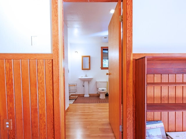 hallway with sink and light wood-type flooring