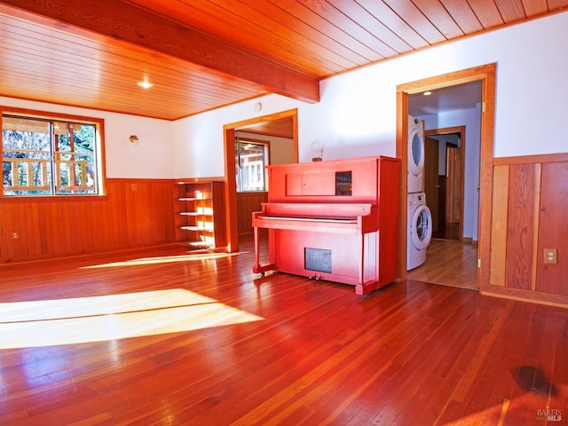 miscellaneous room with beam ceiling, stacked washer / dryer, wooden ceiling, and wood-type flooring