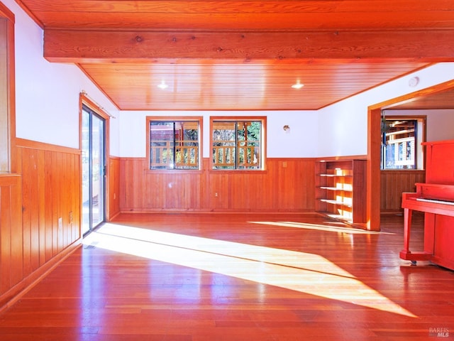 interior space featuring beamed ceiling, hardwood / wood-style floors, wooden walls, and wood ceiling