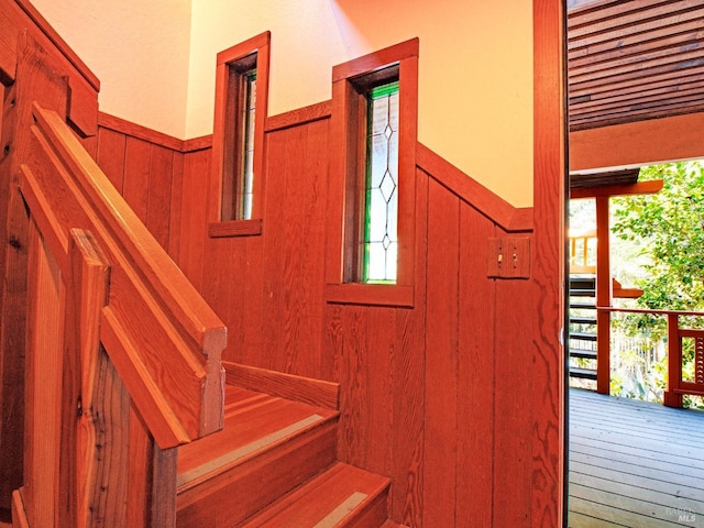 stairway with hardwood / wood-style flooring and wooden walls