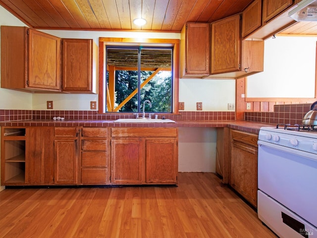 kitchen with tile countertops, sink, wood ceiling, and white stove