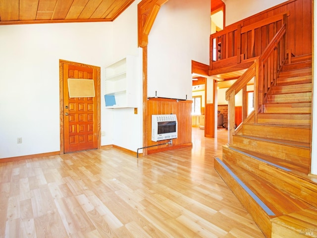 unfurnished living room with light hardwood / wood-style floors, wood ceiling, ornamental molding, and heating unit