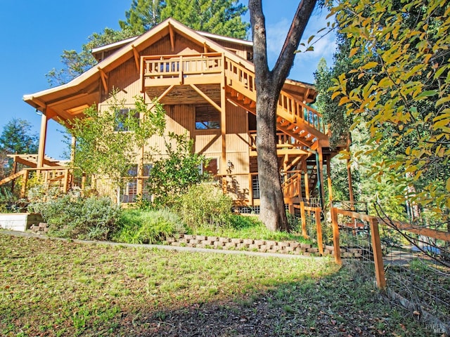 rear view of house with a lawn and a wooden deck