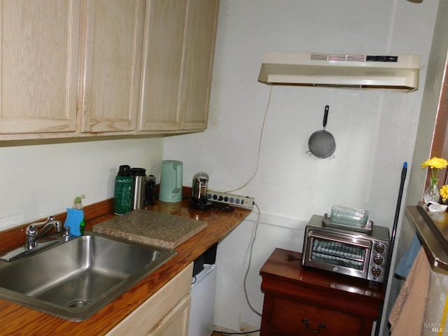 kitchen with light brown cabinets, butcher block counters, and sink