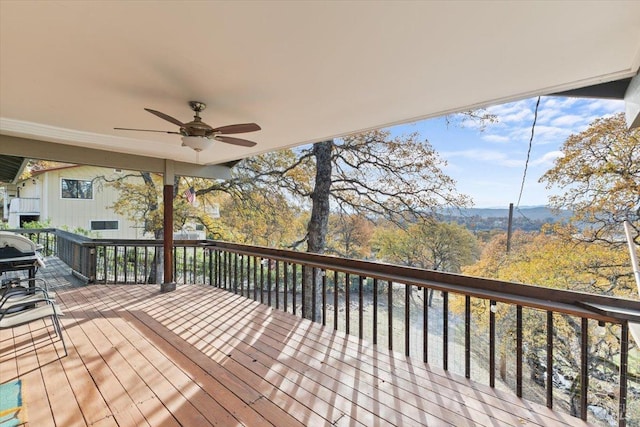 wooden terrace with ceiling fan and area for grilling