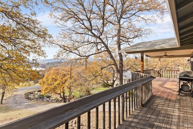 wooden deck featuring area for grilling and ceiling fan