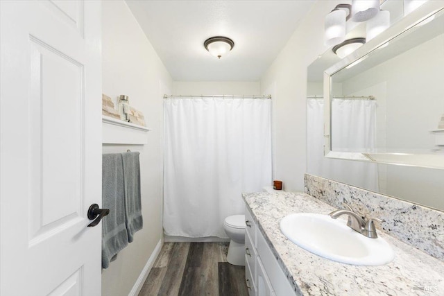 bathroom with wood-type flooring, vanity, and toilet