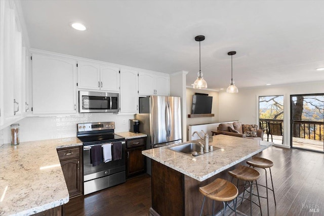 kitchen with a center island with sink, sink, white cabinetry, and stainless steel appliances