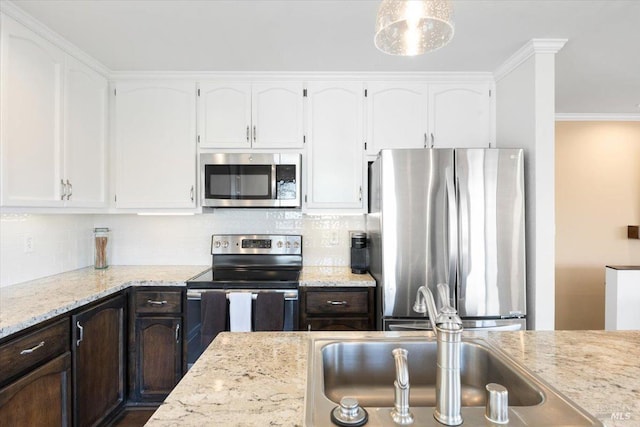 kitchen with decorative backsplash, light stone counters, white cabinetry, and stainless steel appliances