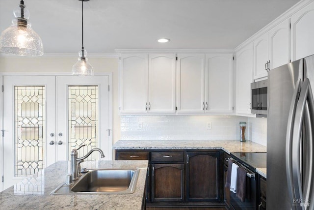 kitchen with white cabinetry, sink, stainless steel appliances, and decorative light fixtures