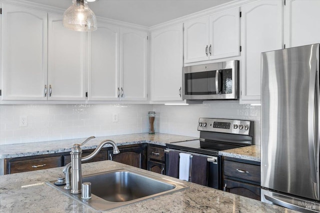 kitchen featuring decorative backsplash, appliances with stainless steel finishes, white cabinetry, and sink