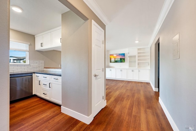 kitchen with white cabinets, dark hardwood / wood-style floors, stainless steel dishwasher, and ornamental molding