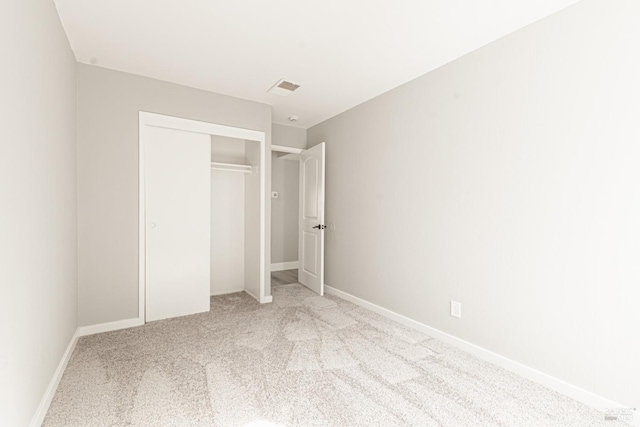 unfurnished bedroom with visible vents, a closet, baseboards, and carpet flooring