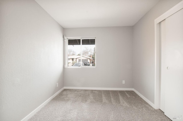 empty room with carpet and baseboards