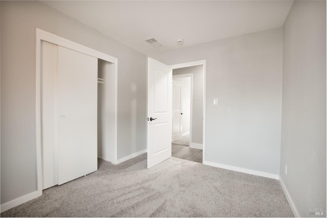 unfurnished bedroom featuring baseboards, a closet, visible vents, and carpet flooring