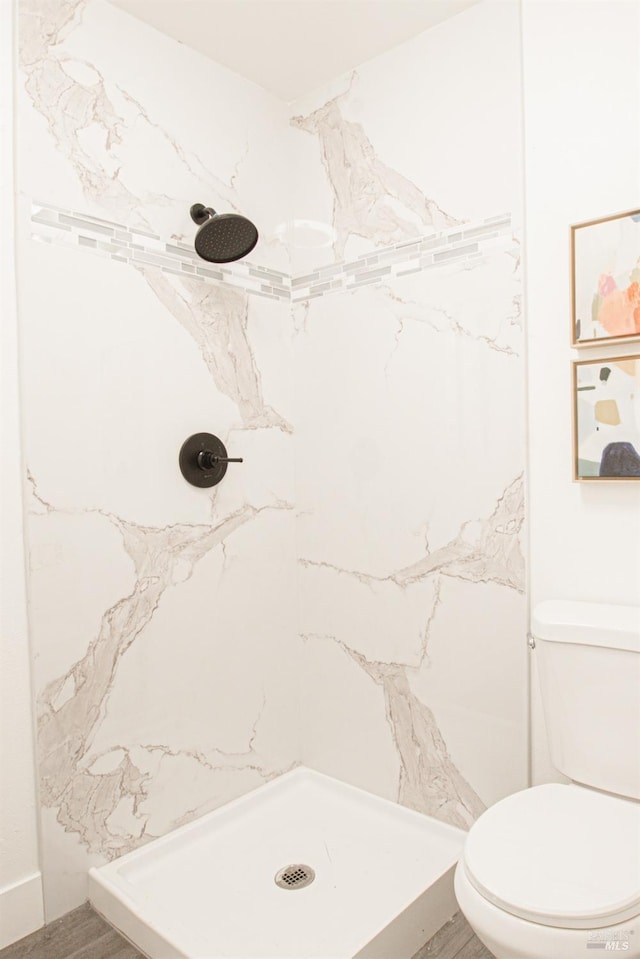 bathroom featuring a shower stall and toilet