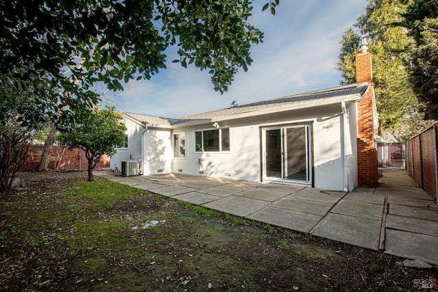 back of property with a chimney, stucco siding, a patio area, central AC, and a fenced backyard