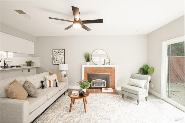 living room with a ceiling fan, wood finished floors, visible vents, and baseboards